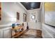 Beautiful foyer features a decorative table, wood flooring, wainscotting, and a modern front door at 9428 Liberty Hill Dr, Mint Hill, NC 28227