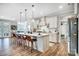 Spacious kitchen featuring a large island with barstool seating, modern lighting, and stainless steel appliances at 9428 Liberty Hill Dr, Mint Hill, NC 28227