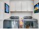 Laundry room with modern LG washer and dryer, overhead cabinets and wall art at 9428 Liberty Hill Dr, Mint Hill, NC 28227