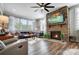 Cozy living room features a stone fireplace with a TV, large windows, and modern furniture at 9428 Liberty Hill Dr, Mint Hill, NC 28227