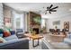 Open-concept living room with stone fireplace, modern furniture, and natural light from the large windows at 9428 Liberty Hill Dr, Mint Hill, NC 28227
