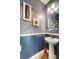 Stylish powder room with blue wainscoting, a pedestal sink and decorative wallpaper at 9428 Liberty Hill Dr, Mint Hill, NC 28227