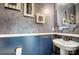 Elegant powder room with pedestal sink, decorative wallpaper and framed art at 9428 Liberty Hill Dr, Mint Hill, NC 28227