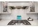 Close up of stove and vent hood with decorative glass cabinets and marble backsplash at 9428 Liberty Hill Dr, Mint Hill, NC 28227