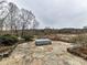 Stone patio with fire pit and serene woodland views at 955 Brafford Dr, Concord, NC 28025