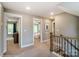 Hallway with neutral walls, wooden railing, and open doorways to other rooms at 102 Ellsworth Rd # 43, Mooresville, NC 28115