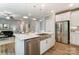 Open-concept kitchen with stainless steel appliances, white cabinets, large island, and hardwood floors at 102 Ellsworth Rd # 43, Mooresville, NC 28115