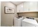 Functional laundry room featuring a washer, dryer, and white cabinets for storage at 102 Ellsworth Rd # 43, Mooresville, NC 28115
