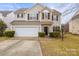 Two-story house with a white garage door and landscaped lawn at 10315 Samuels Way Dr, Huntersville, NC 28078