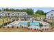 Community pool featuring abundant lounge chairs and umbrellas, set among townhouse style homes and lush greenery at 3116 Beacon Heights Rd, Indian Land, SC 29707