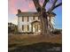 Two-story farmhouse with white siding, brown shutters, and a large tree at 3433 Grey Rd, Davidson, NC 28036