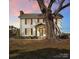 Two-story farmhouse with shutters, landscaping, and a large tree in the front yard at 3433 Grey Rd, Davidson, NC 28036