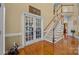 Grand foyer with hardwood floors, staircase with white risers, and elegant French doors leading to another room at 561 Keystone Nw Ct, Concord, NC 28027