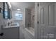 Bright bathroom with double sink, tiled shower and tub combo with modern fixtures, and sleek lighting at 6305 Dale Ave, Charlotte, NC 28212