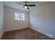 This empty bedroom features hardwood floors, white walls, and a window with a view of trees outside at 6305 Dale Ave, Charlotte, NC 28212