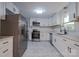 Well-lit kitchen featuring stainless steel appliances, white cabinets, and unique marble-patterned floors at 6305 Dale Ave, Charlotte, NC 28212