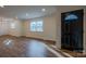Open-concept living room featuring hardwood floors and a black front door with decorative window at 6305 Dale Ave, Charlotte, NC 28212