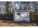 A white, wooden shed nestled among trees at 6305 Dale Ave, Charlotte, NC 28212