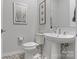 Stylish powder room with patterned tile flooring, pedestal sink, and modern decor at 8016 Brookbank Dr, Charlotte, NC 28269