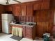 Small kitchen with wood cabinets and vintage wallpaper at 1108 Cone Ave, Pineville, NC 28134
