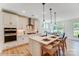 Modern white kitchen featuring a large island with seating, pendant lights, and stainless steel appliances at 128 Ballantree Rd # 46, Mooresville, NC 28115