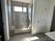 Bathroom featuring a walk-in shower with glass enclosure, light tiling, and tiled flooring at 14247 Canemeadow Dr, Charlotte, NC 28278