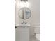 Modern powder room with white vanity and a round black framed mirror at 177 Olympia Dr, Mooresville, NC 28117