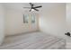 A spacious bedroom with light wood floors, neutral walls, a ceiling fan, and bright windows at 177 Olympia Dr, Mooresville, NC 28117
