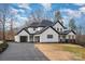 A modern farmhouse exterior featuring a three-car garage, sleek driveway and manicured front yard at 177 Olympia Dr, Mooresville, NC 28117
