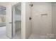 Modern tiled shower featuring a built-in niche, accented by an attached walk-in closet at 177 Olympia Dr, Mooresville, NC 28117