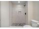 This contemporary shower features light tile, a pebble floor, and modern fixtures at 177 Olympia Dr, Mooresville, NC 28117