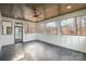 A screened porch features black tile floors, a ceiling fan, and white shiplap wainscoting with scenic views at 177 Olympia Dr, Mooresville, NC 28117