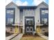Modern three-story townhome with yellow door and gray siding at 2124 Electric Ln, Charlotte, NC 28205