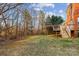 Expansive backyard featuring a wooden deck, lush greenery, and serene wooded backdrop at 2608 Golden Bell Dr, Gastonia, NC 28056