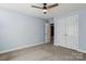 Bright bedroom featuring carpet, ceiling fan, and double doors to closet at 2608 Golden Bell Dr, Gastonia, NC 28056