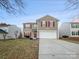 Two-story house with tan siding, red shutters, and a two-car garage at 3522 Larkhaven Village Dr, Charlotte, NC 28215