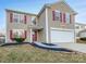 Two story house with tan siding, red shutters, and a two-car garage at 3522 Larkhaven Village Dr, Charlotte, NC 28215