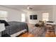 Spacious bedroom with hardwood floors, large TV, and comfortable seating area at 395 Paulownia Dr, China Grove, NC 28023