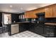 Modern kitchen with dark cabinets, stainless steel appliances, and geometric tile floor at 395 Paulownia Dr, China Grove, NC 28023
