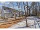 House backyard with trees and patchy snow at 8506 Milton Morris Dr, Charlotte, NC 28227