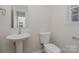 Updated half bathroom with pedestal sink and toilet at 8506 Milton Morris Dr, Charlotte, NC 28227