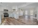 Modern kitchen open to living area with white cabinets and stainless steel appliances at 8506 Milton Morris Dr, Charlotte, NC 28227