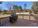 A grill sits on a wooden deck overlooking a large backyard with trees and a fence at 857 Spelman Dr, Indian Land, SC 29707