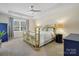 Bright bedroom featuring a tray ceiling, a brass bed frame, and neutral carpeting at 857 Spelman Dr, Indian Land, SC 29707