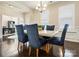 Bright dining room featuring a modern chandelier, a marble table, and stylish navy blue chairs at 857 Spelman Dr, Indian Land, SC 29707