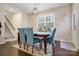 Cozy dining room with a wooden table, blue chairs, plantation shutters and stylish light fixture at 857 Spelman Dr, Indian Land, SC 29707
