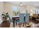 Bright dining area with wooden table, seating for four, plantation shutters, and modern light fixture at 857 Spelman Dr, Indian Land, SC 29707