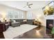 Cozy living room with a fireplace, large sectional sofa, ceiling fan, and plantation shutters at 857 Spelman Dr, Indian Land, SC 29707