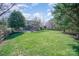 Expansive backyard with well-maintained lawn and patio featuring fire pit and home in the background at 10111 Grimsby Ct, Huntersville, NC 28078