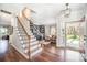 Inviting foyer with hardwood floors, staircase, and view into the living room at 10111 Grimsby Ct, Huntersville, NC 28078